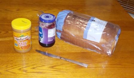 Photo of peanut butter, jelly, bread and knife on a table